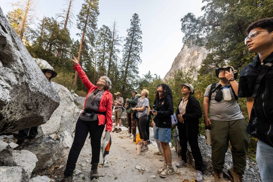Professor shows students a large rock at Yosemite National Park.