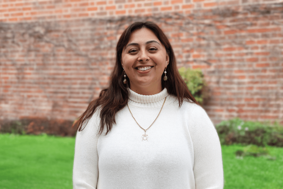 A picture of Jeniffer Morfin standing in front of a brick wall.